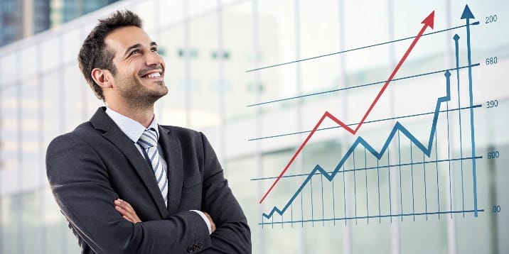 un-empresario-sonriendo-con-un-gr-fico-de-eficienc Un empresario sonriendo con un gráfico de eficiencia y rentabilidad ascendente de fondo, simbolizando el éxito por mejora continua